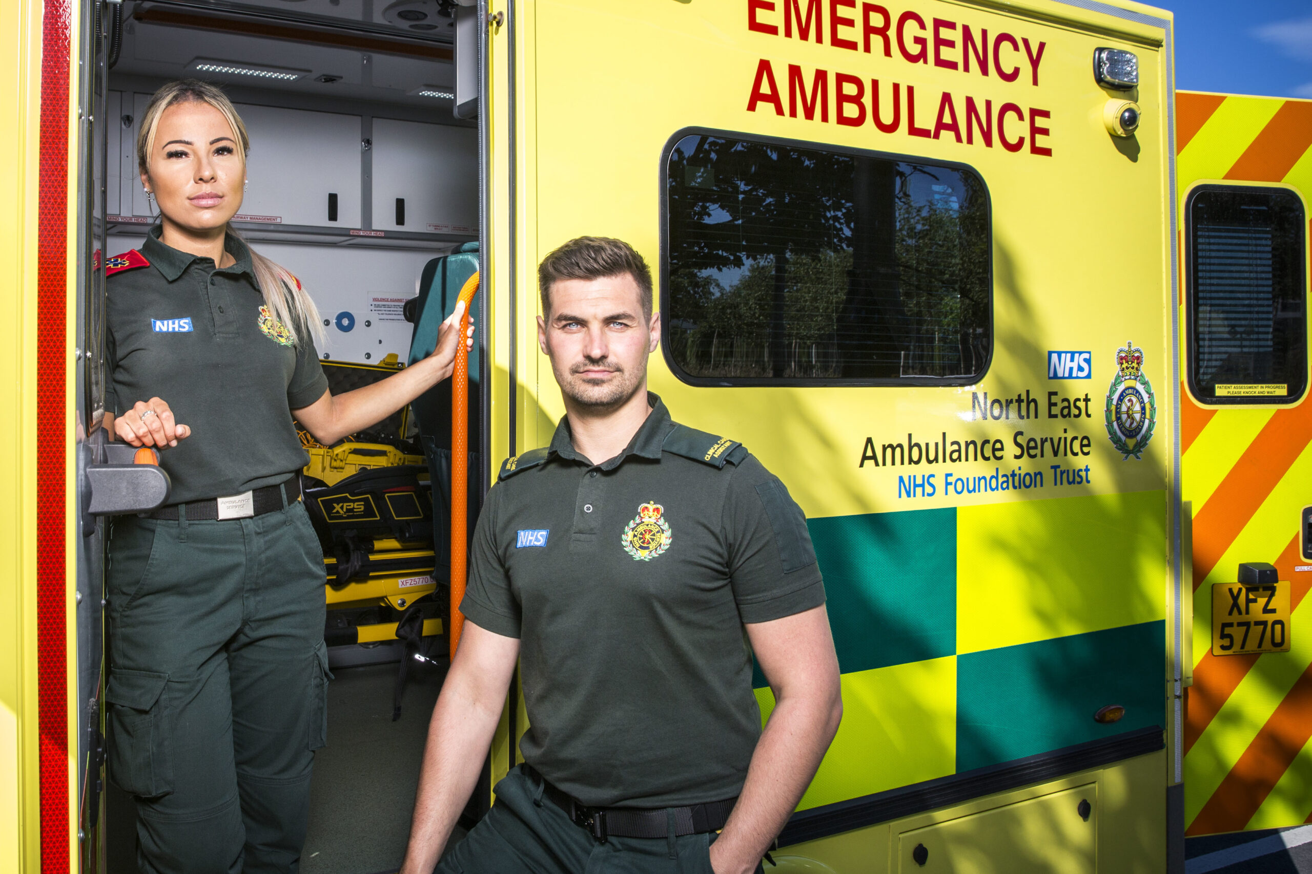 Becca and Chris stand next to their Ambulance