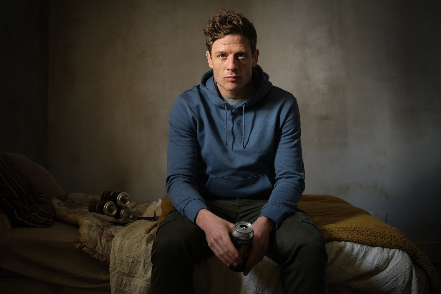 Tommy Lee Royce frowns on a bed, holding a beer in Happy Valley episode 5