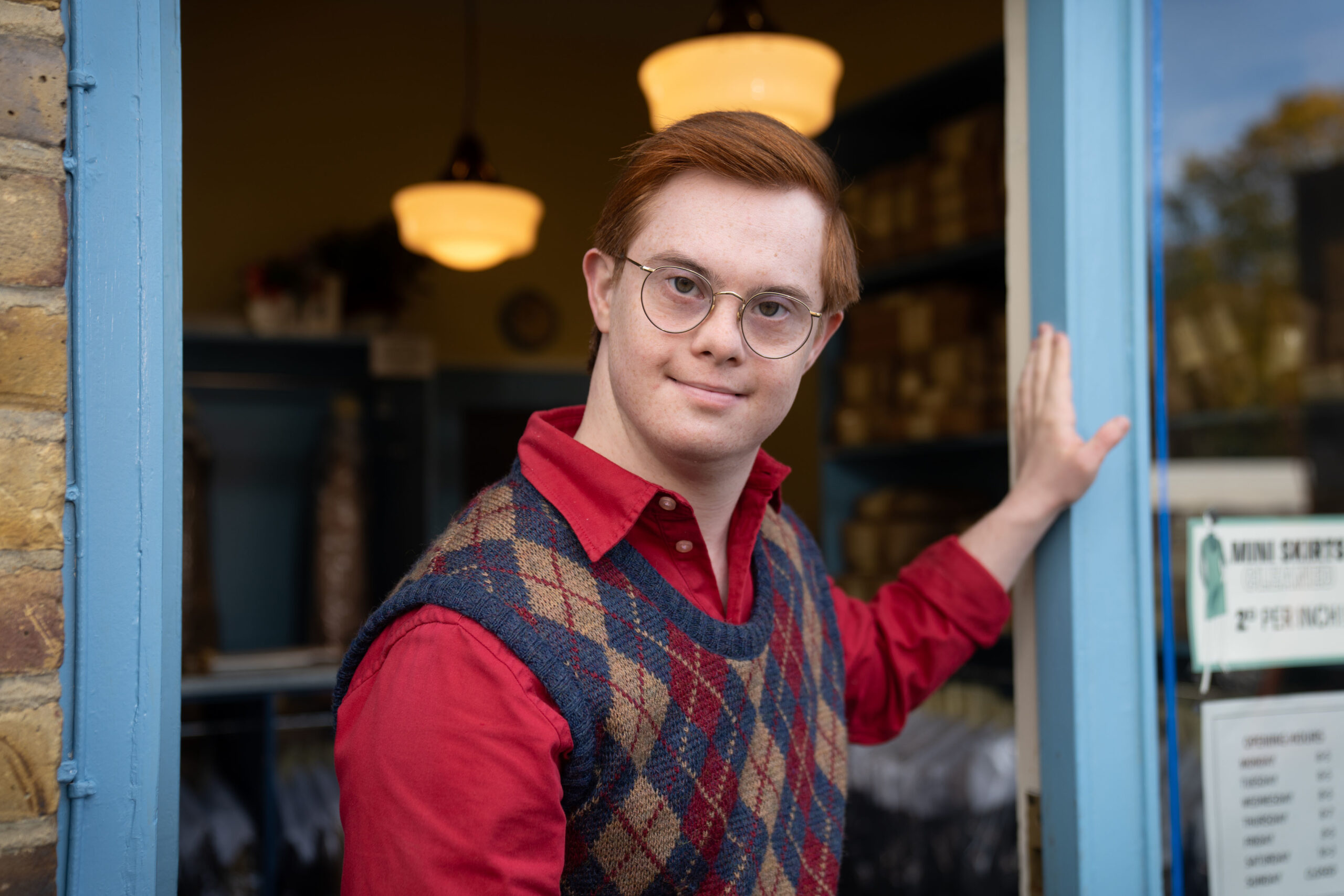 Reggie smiles in red jumper in Call the Midwife