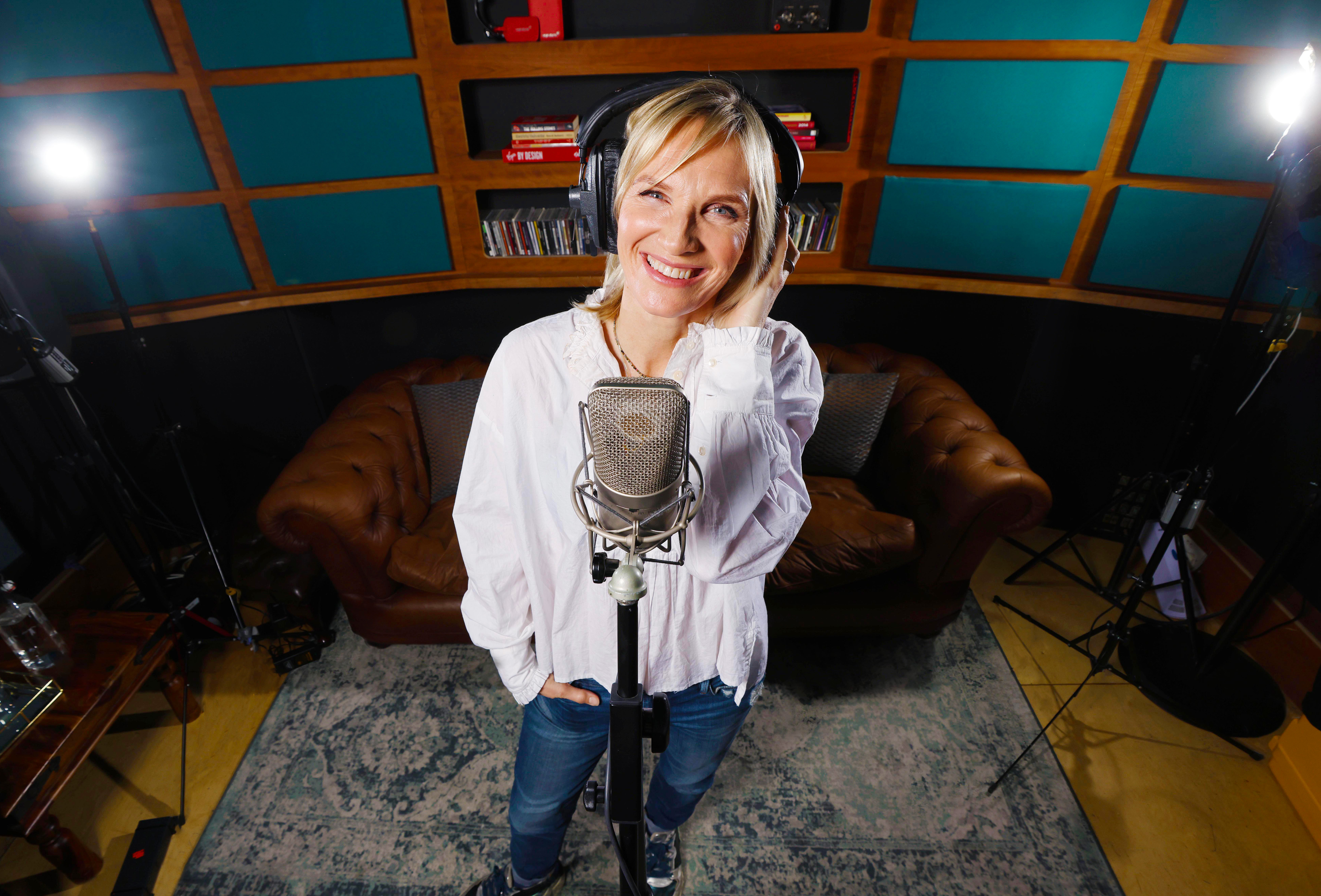 Jo Whiley standing behind a microphone talking about holidays