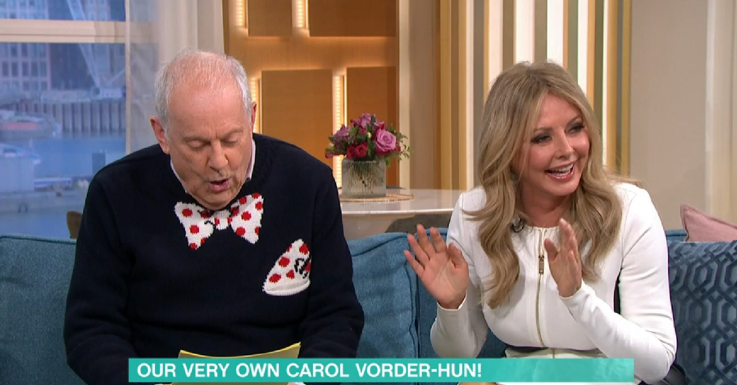 Gyles Brandreth looking down and Carol Vorderman laughing on This Morning