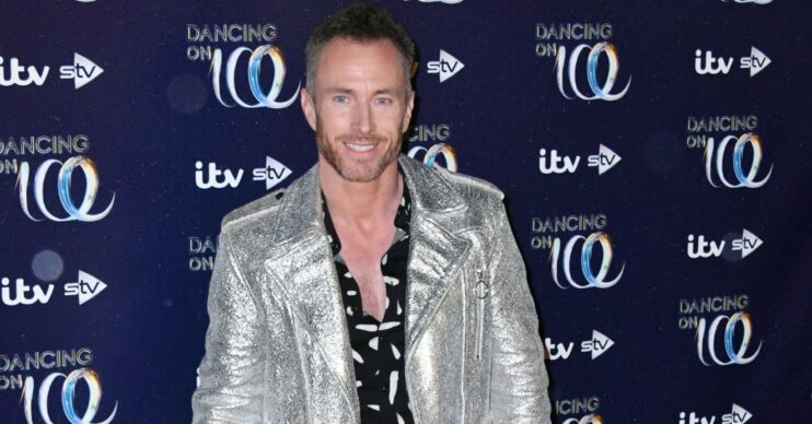 James Jordan smiling and wearing a shiny silver leather jacket