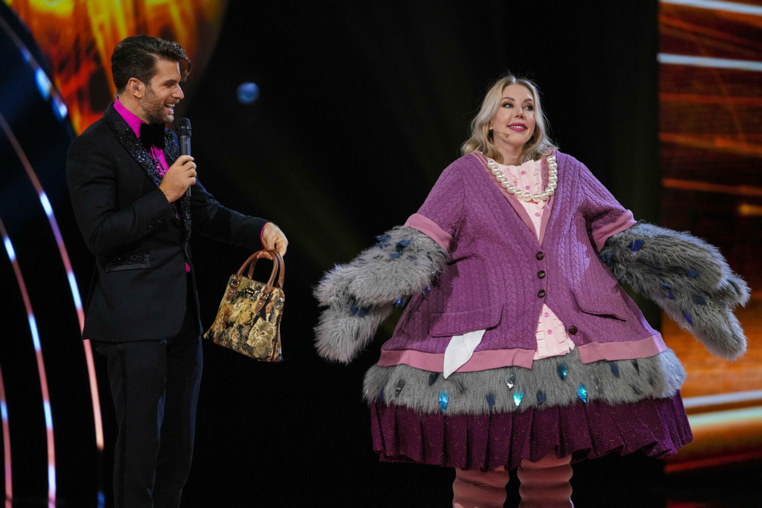 Joel Dommett smiles as Katherine Ryan reveals herself as the Pigeon