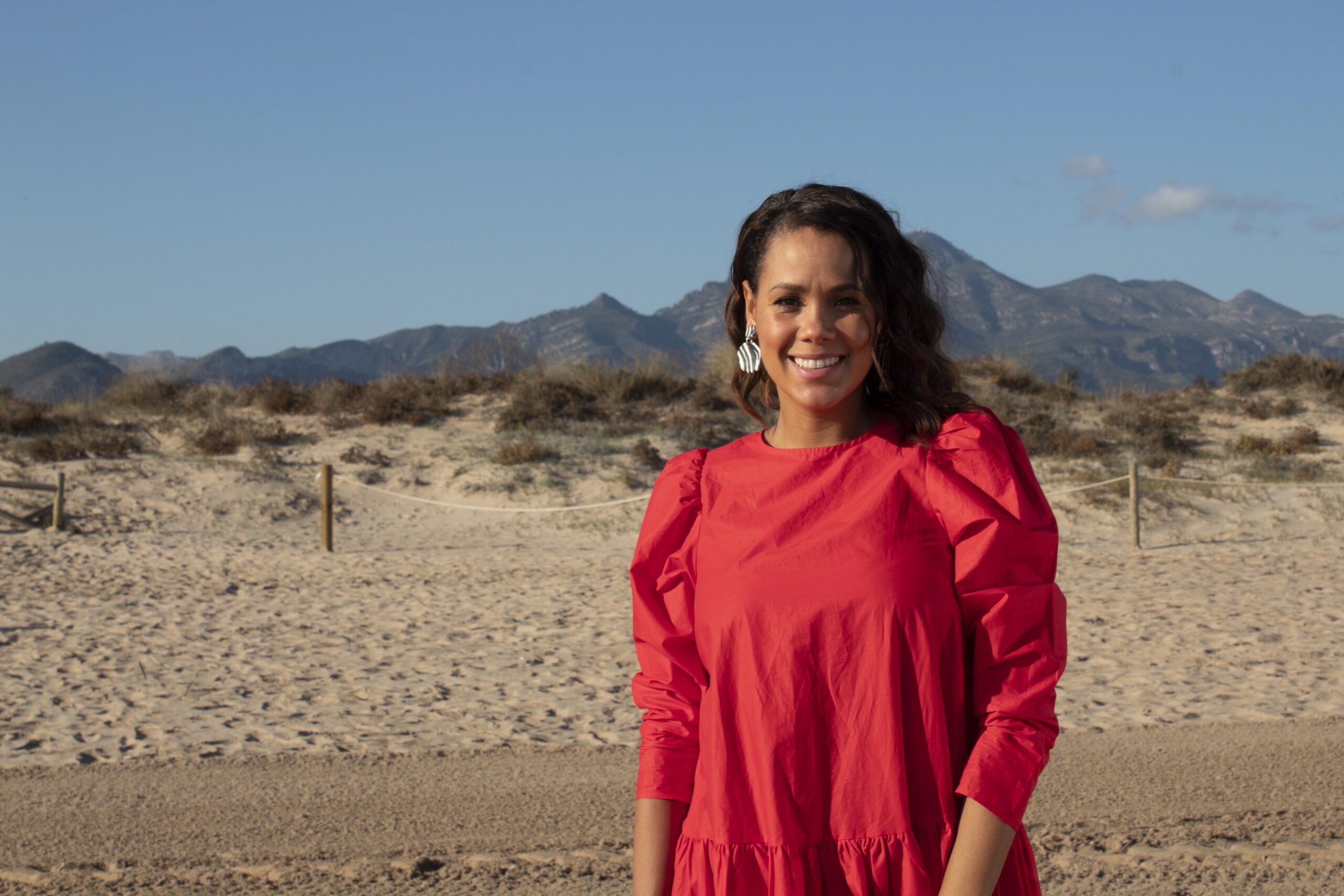 Jean Johansson posing on the beach in a red dress