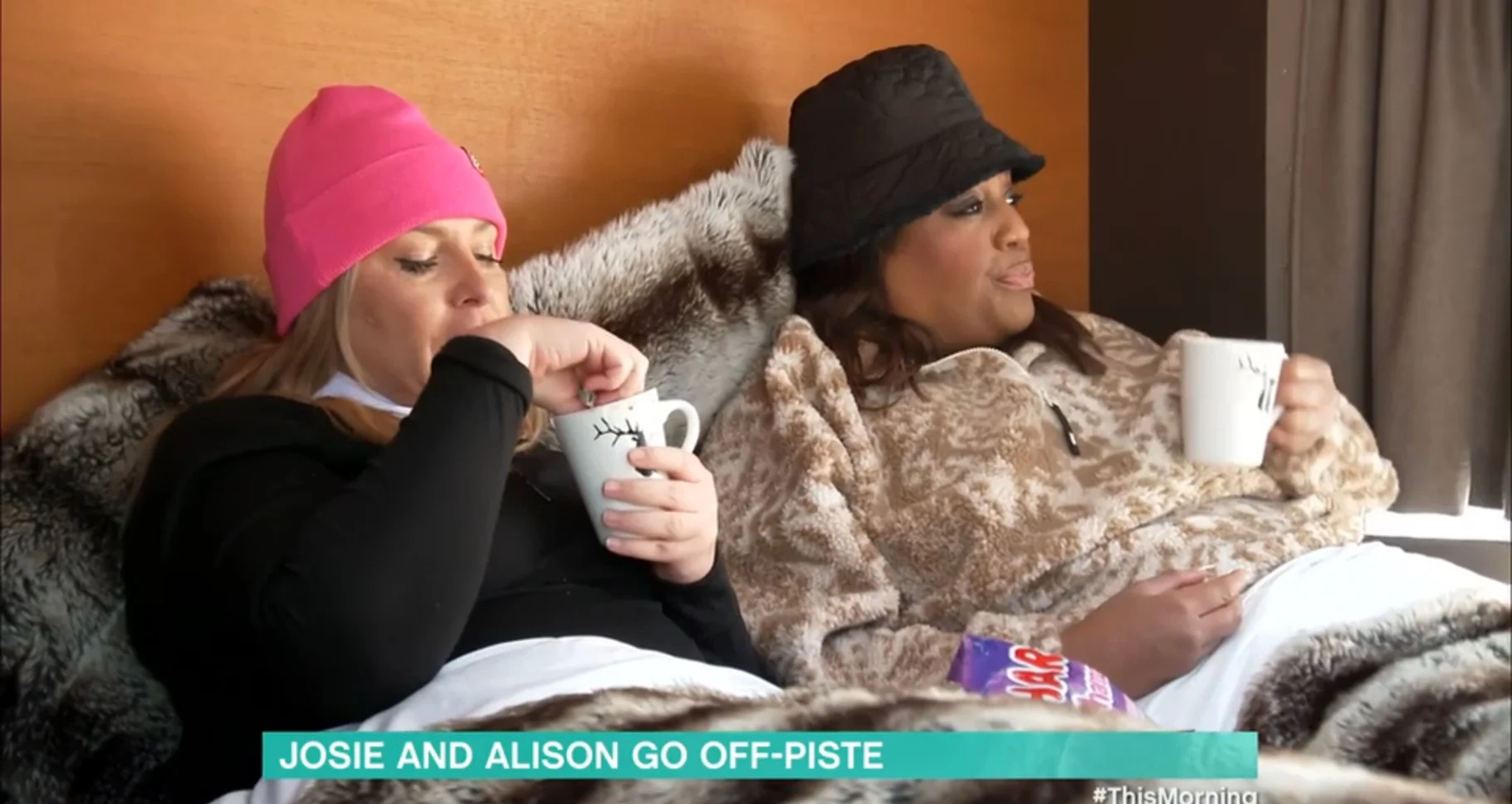 Josie Gibson and Alison Hammond drinking tea in bed, wrapped up warm 