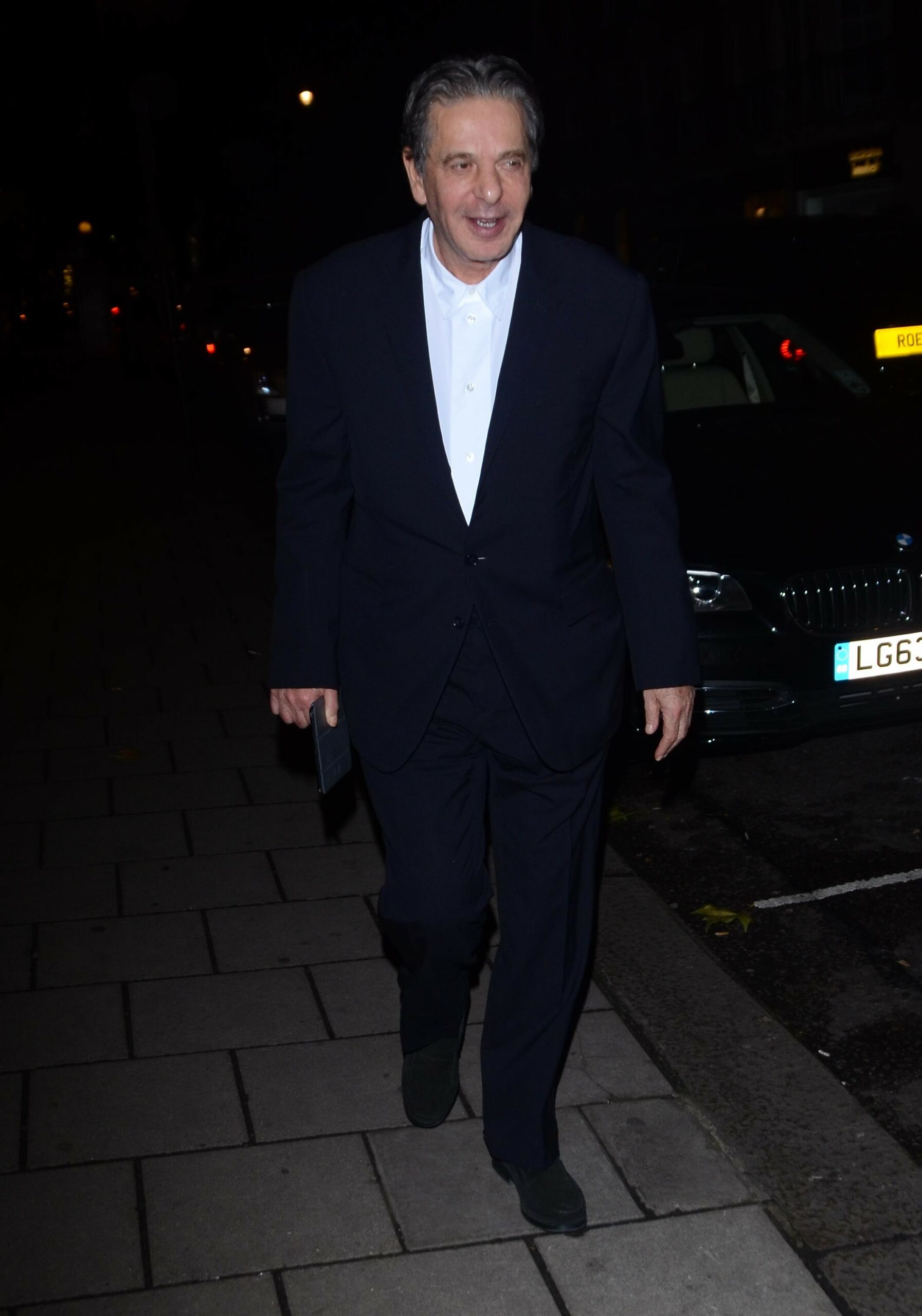 Charles Saatch walking in suit on night out