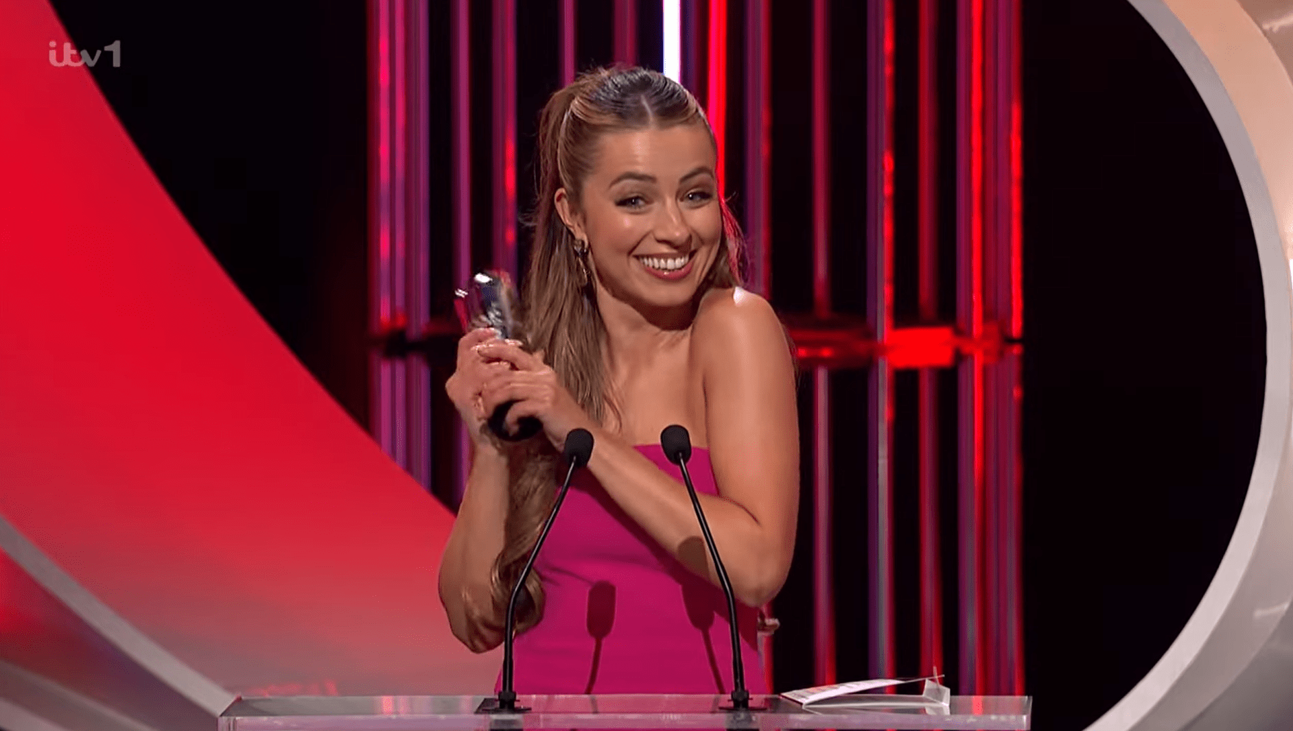Coronation Street star Charlotte Jordan clutches her British Soap Award after accepting it and grins