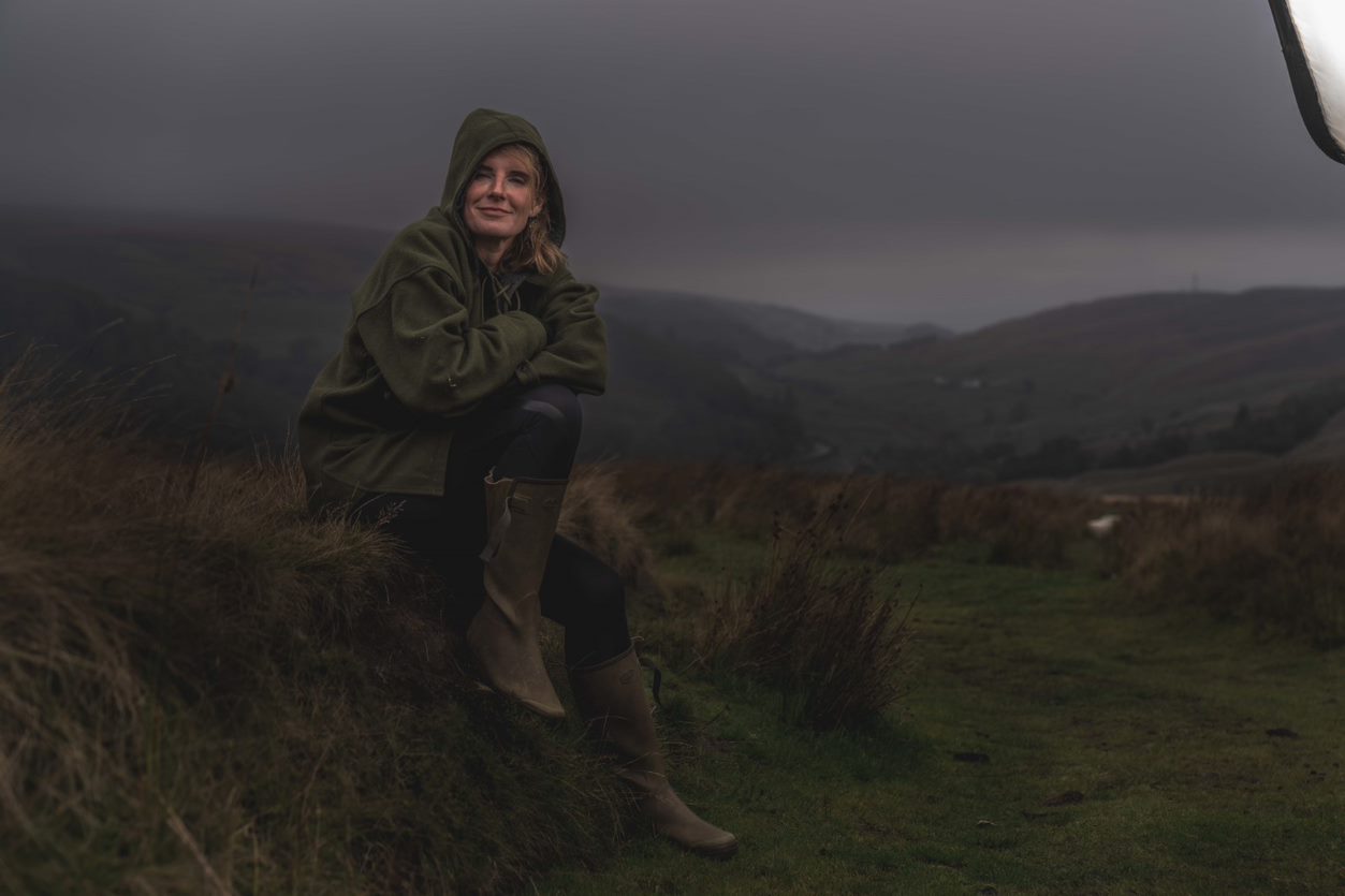 Amanda Owen sitting in a field in Farming Livies