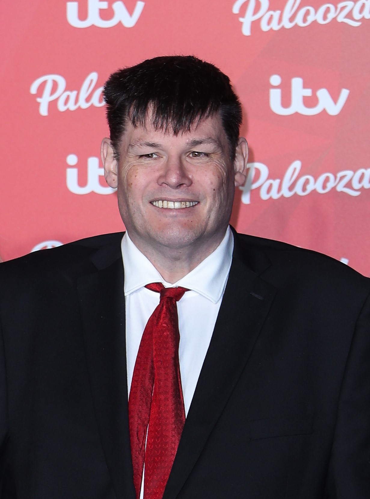 Mark Labbett smiling in suit at ITV Palooza