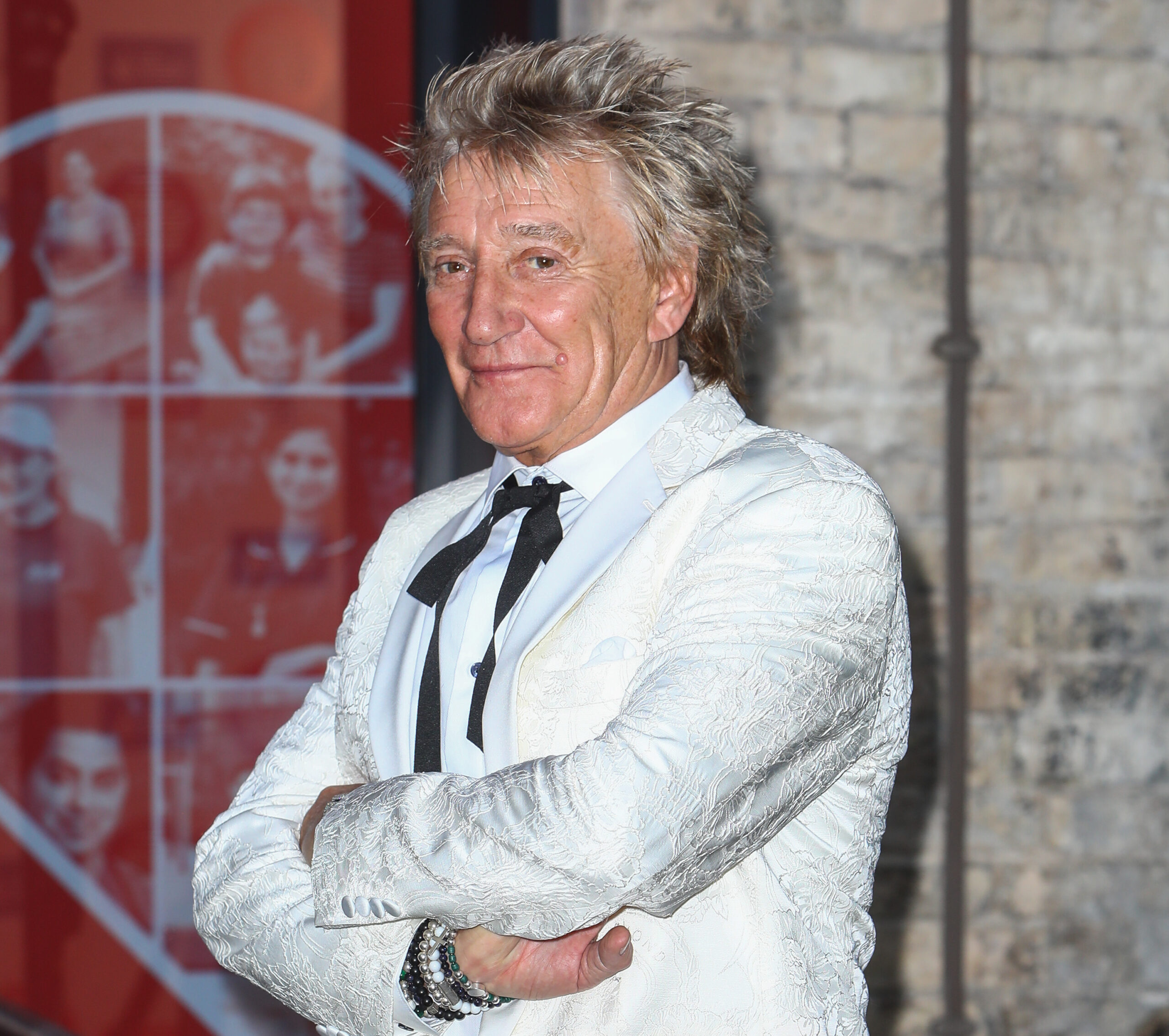 Rod Stewart smiling wearing white