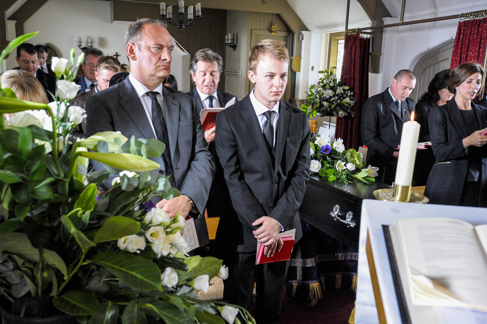 Emmerdale's Thomas King is standing with Jimmy King at a funeral