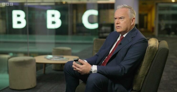 Huw Edwards holds a phone