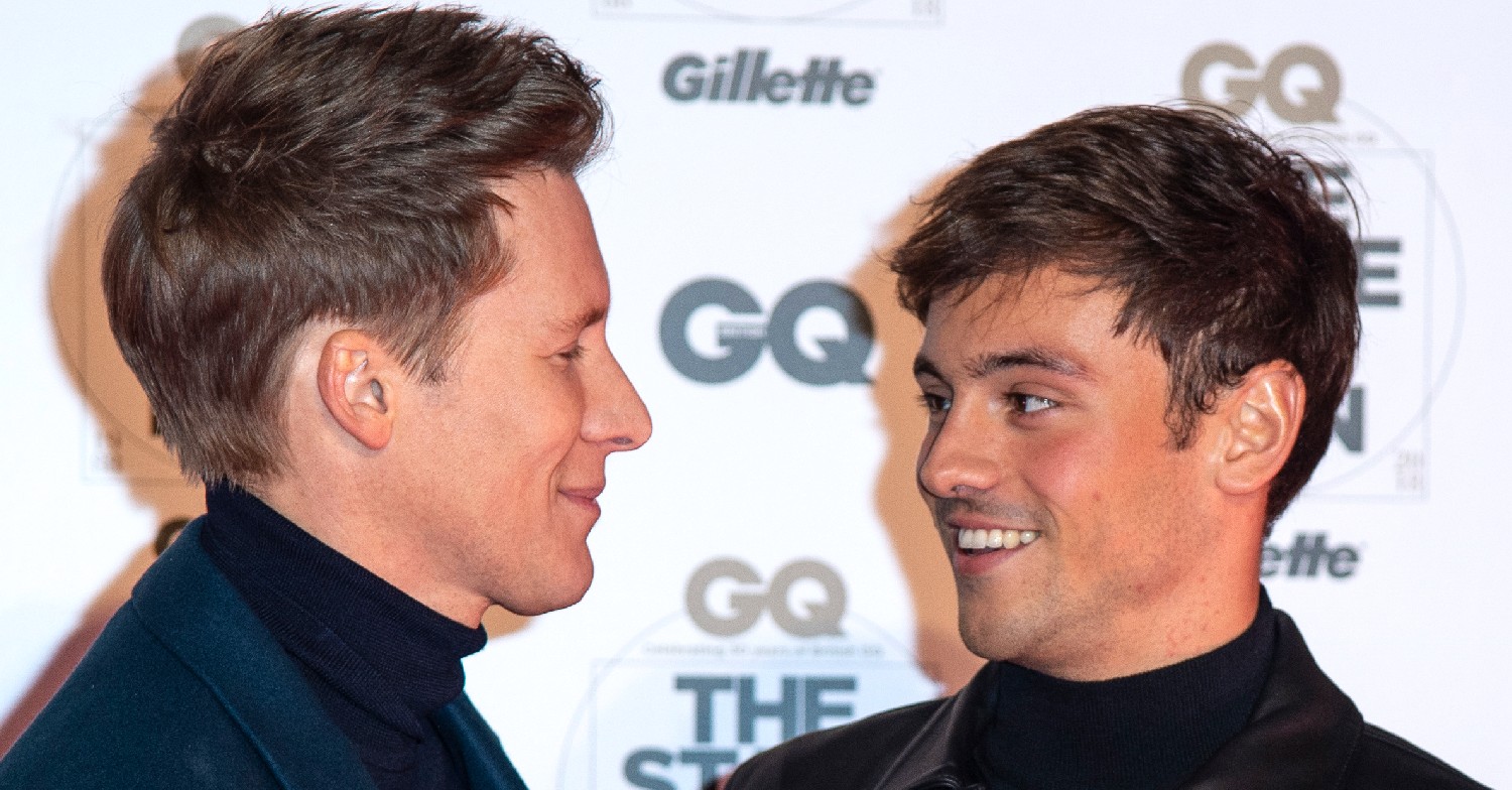 Dustin Lance Black and Tom Daley smiling at each other 