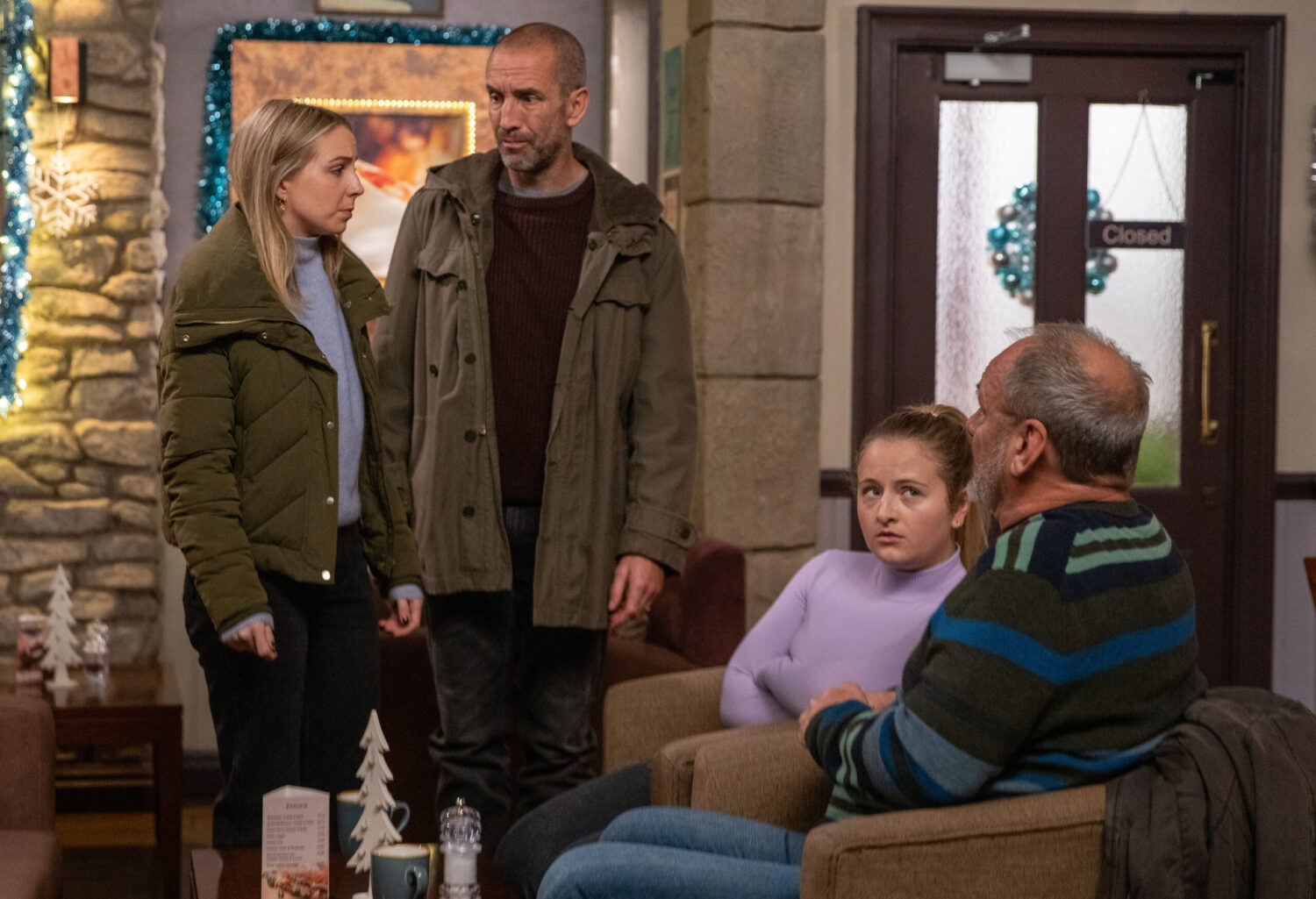 Belle, Sam, Amelia and Jimmy serious in the café