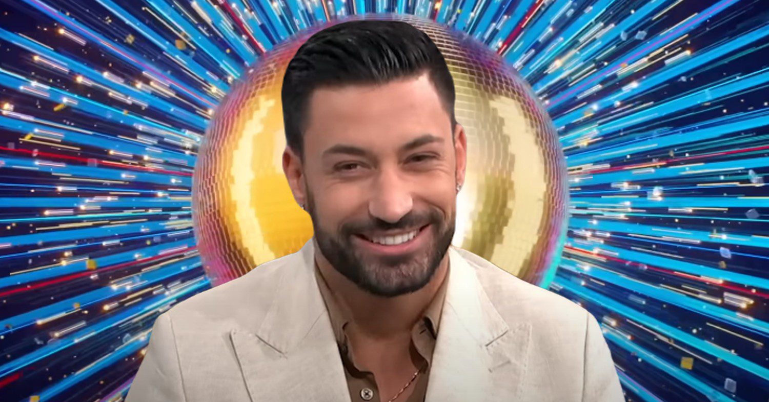 Giovanni Pernice smiling in front of Strictly logo
