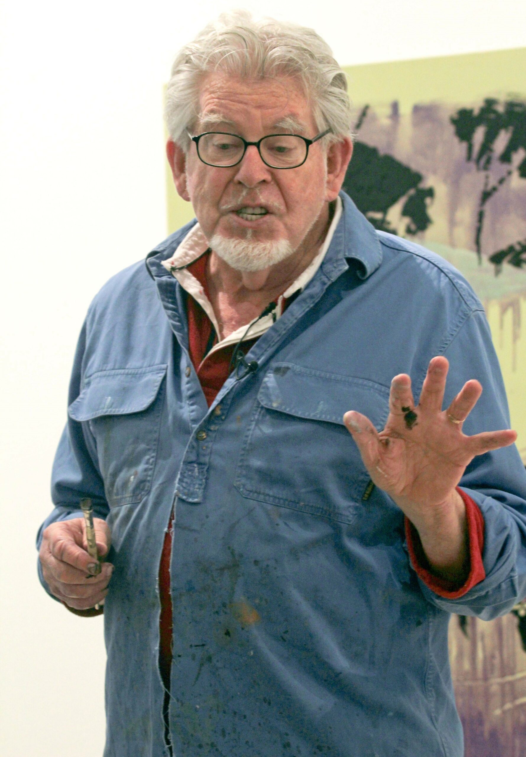 Rolf Harris talking in blue shirt