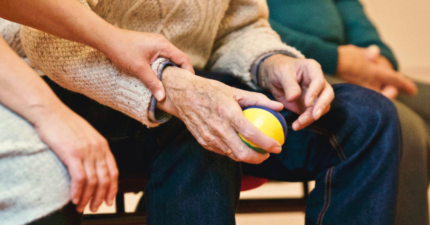 An old person holding a ball