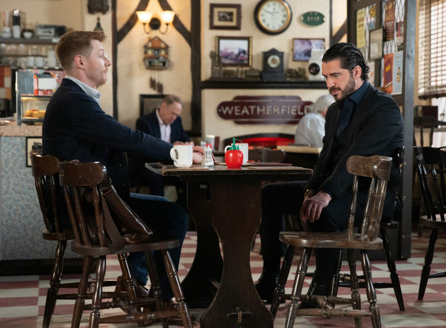 Daniel and Adam talk seriously in the cafe in Corrie