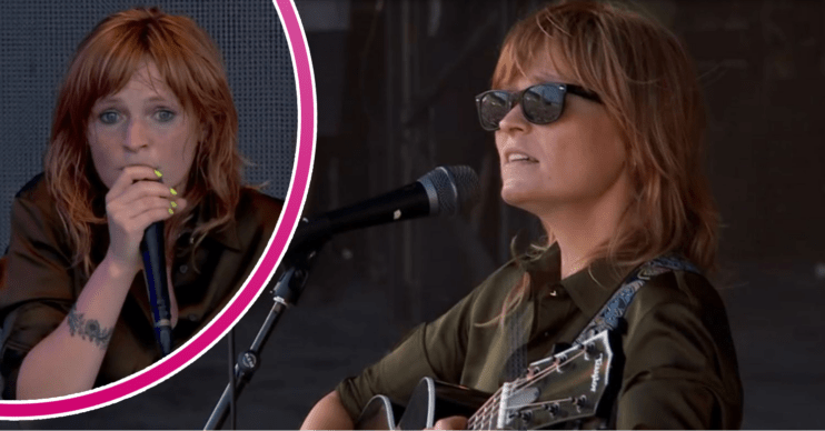 Singer Billy Nomates on stage at Glastonbury with a guitar and microphone