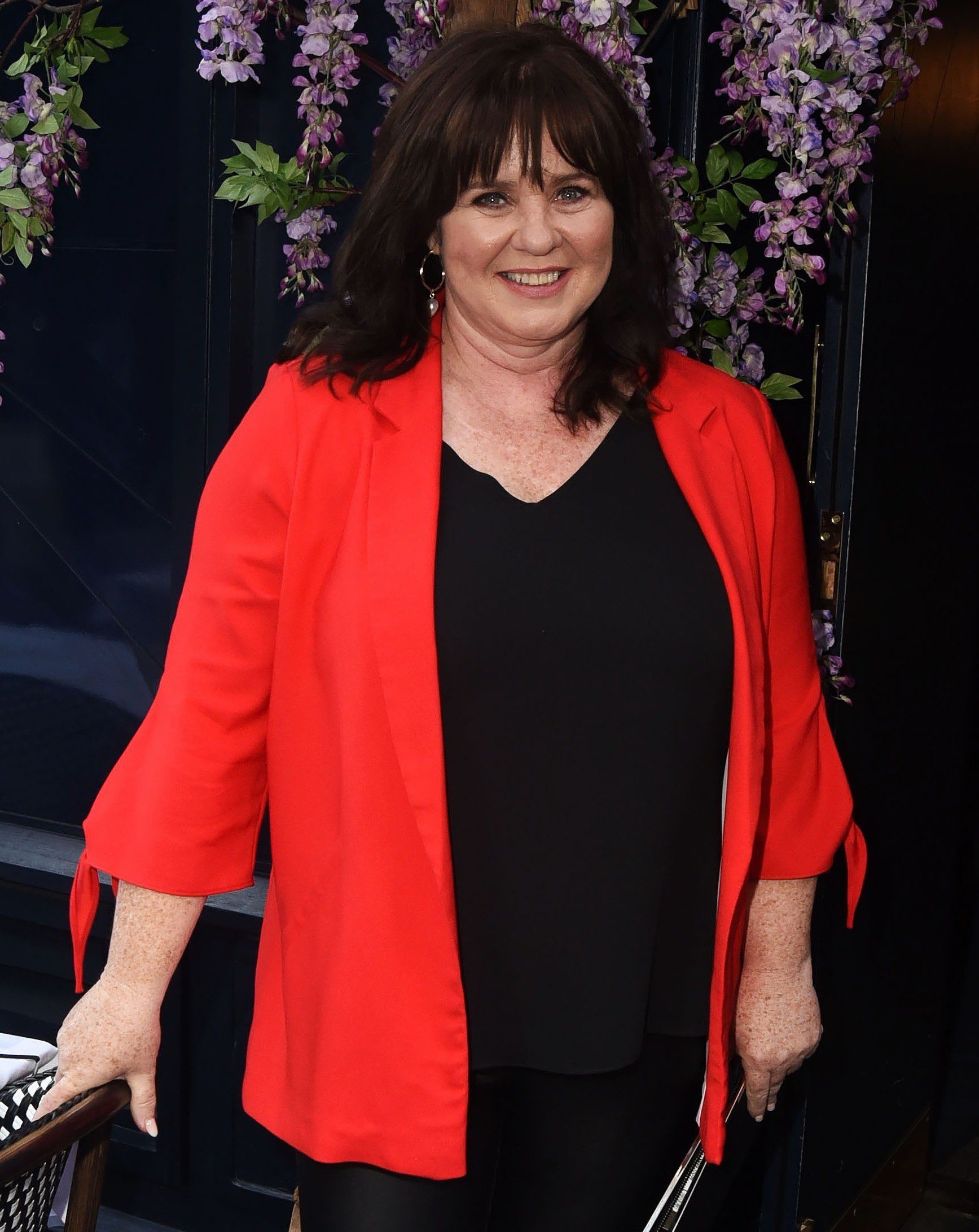 Coleen Nolan smiling in red blazer
