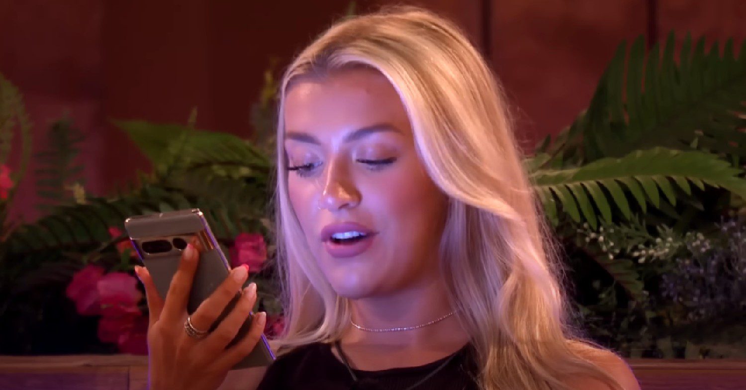 Molly reading a text on Love Island