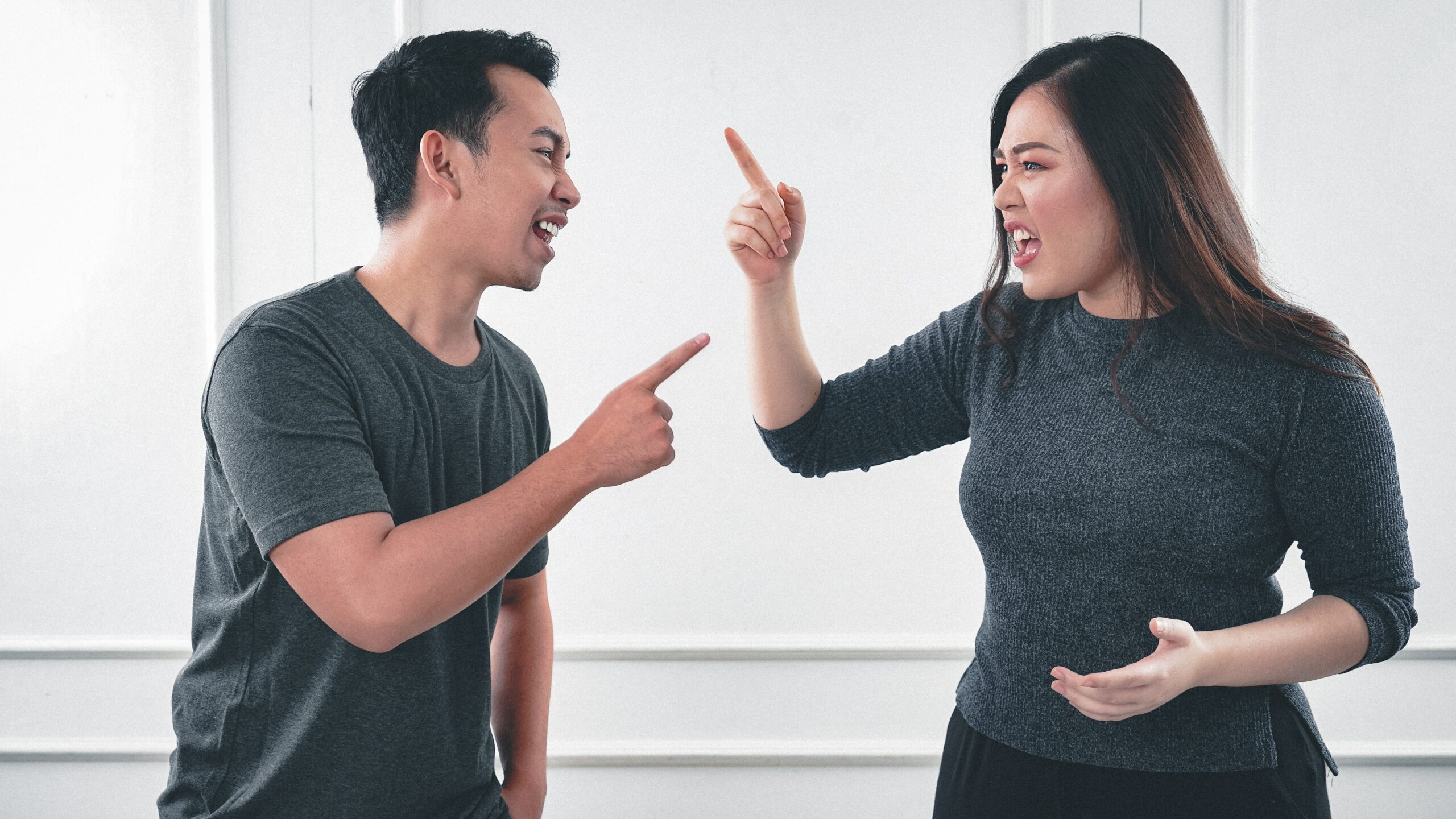 Couple point at each other