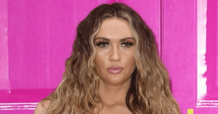 Charlotte Dawson looking straight faced against a pink door