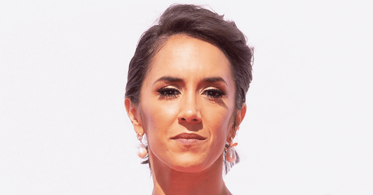 Janette Manrara with her hair up against a white background