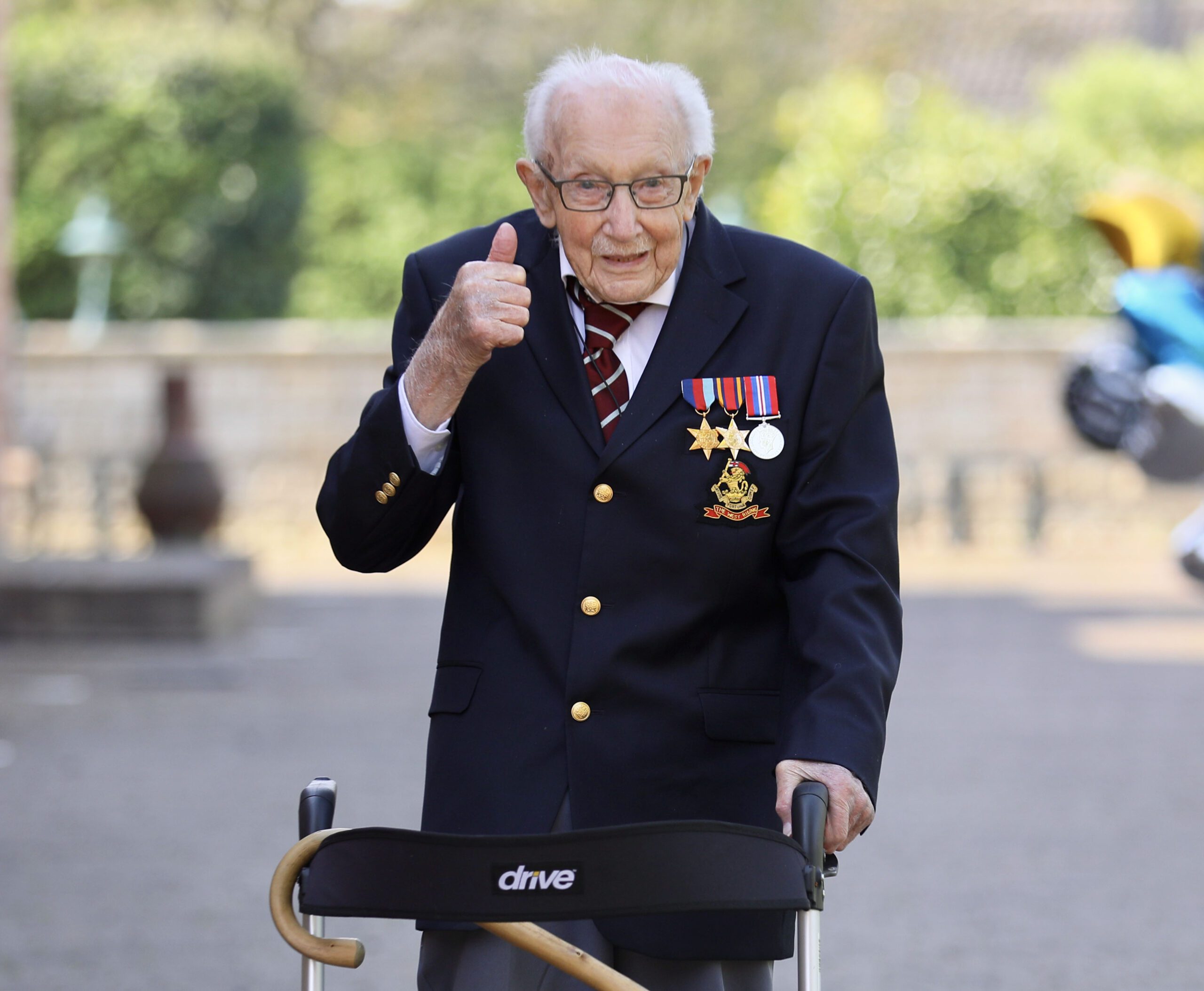 Captain Tom Moore giving a thumbs up with his walking frame