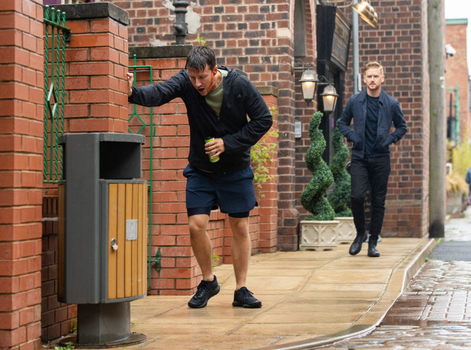 Ryan is holding onto a wall as Gary watches on in the distance