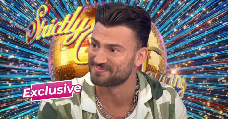 Jake Quickenden smiling in front of Strictly background
