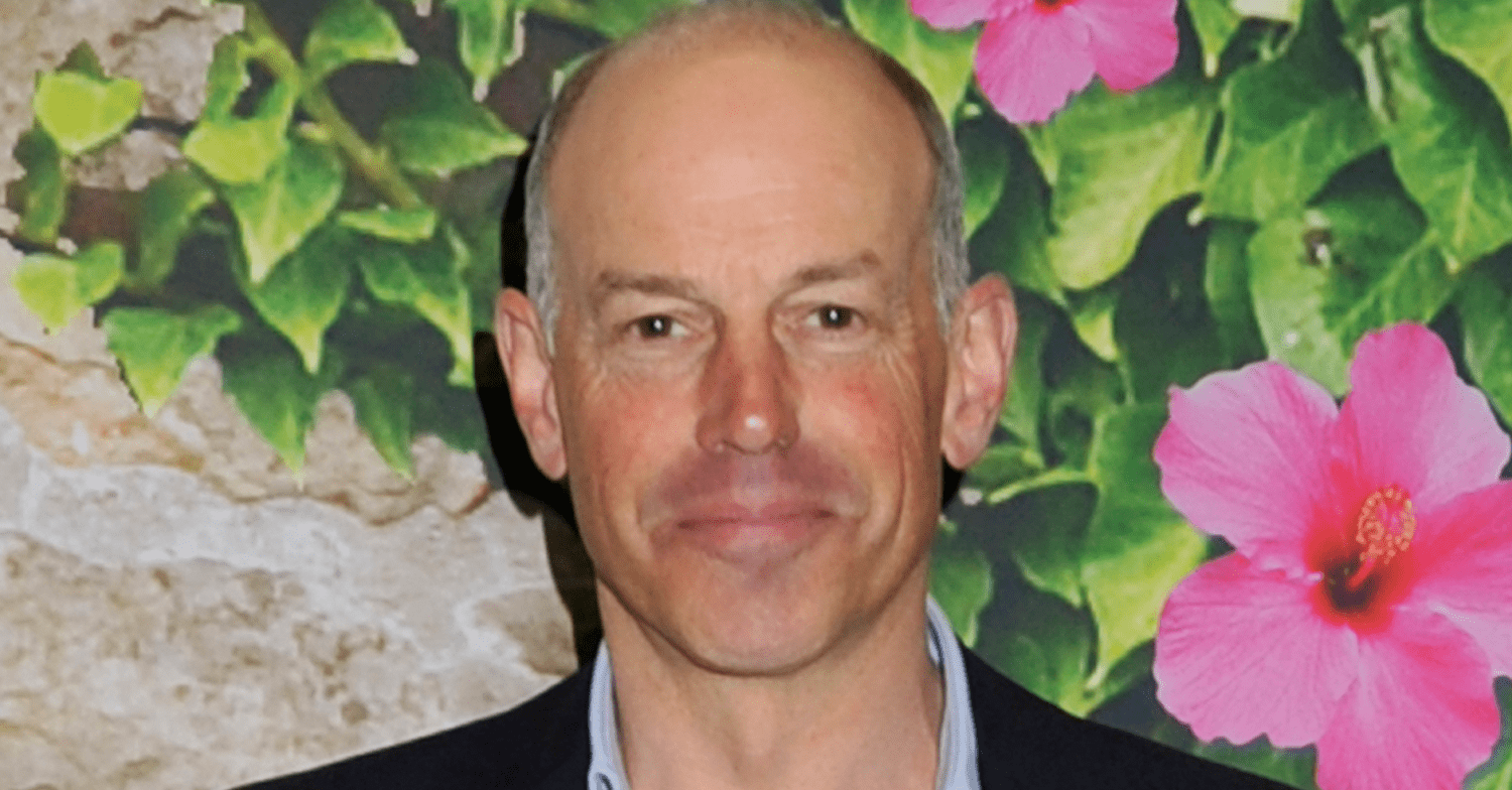 Phil Spencer straight faced against a flower wall