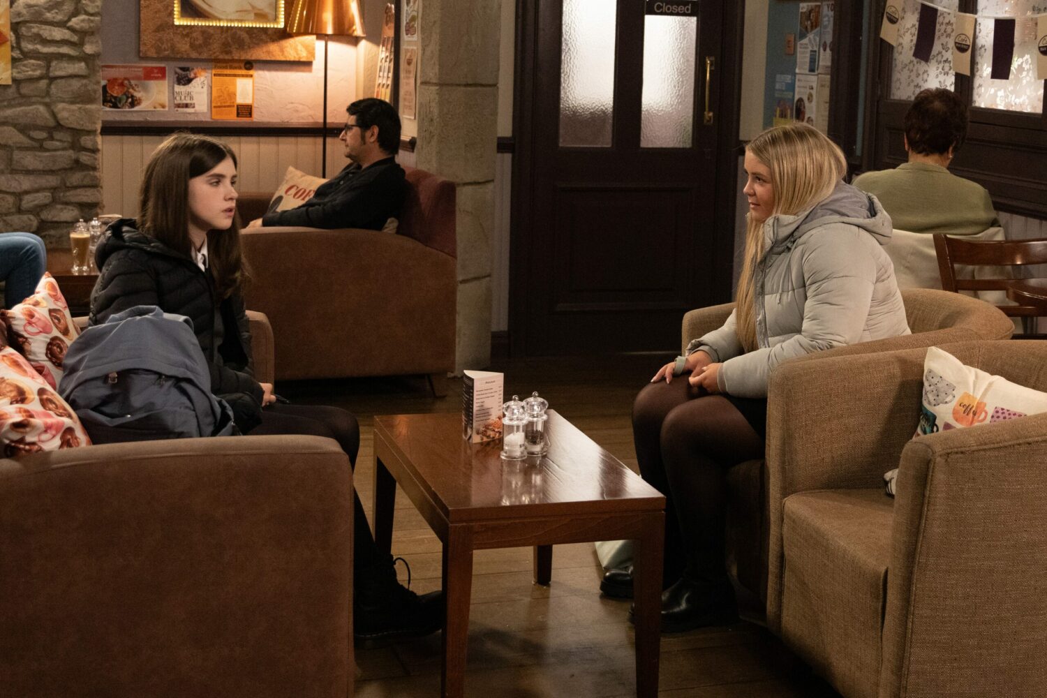 Amelia looks unsure as Cathy talks to her in the cafe in Emmerdale