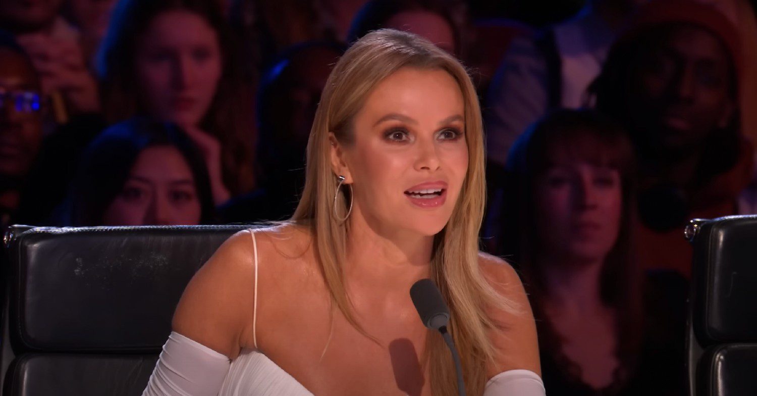 Amanda Holden in a white dress talking while on ITV's Britain's Got Talent