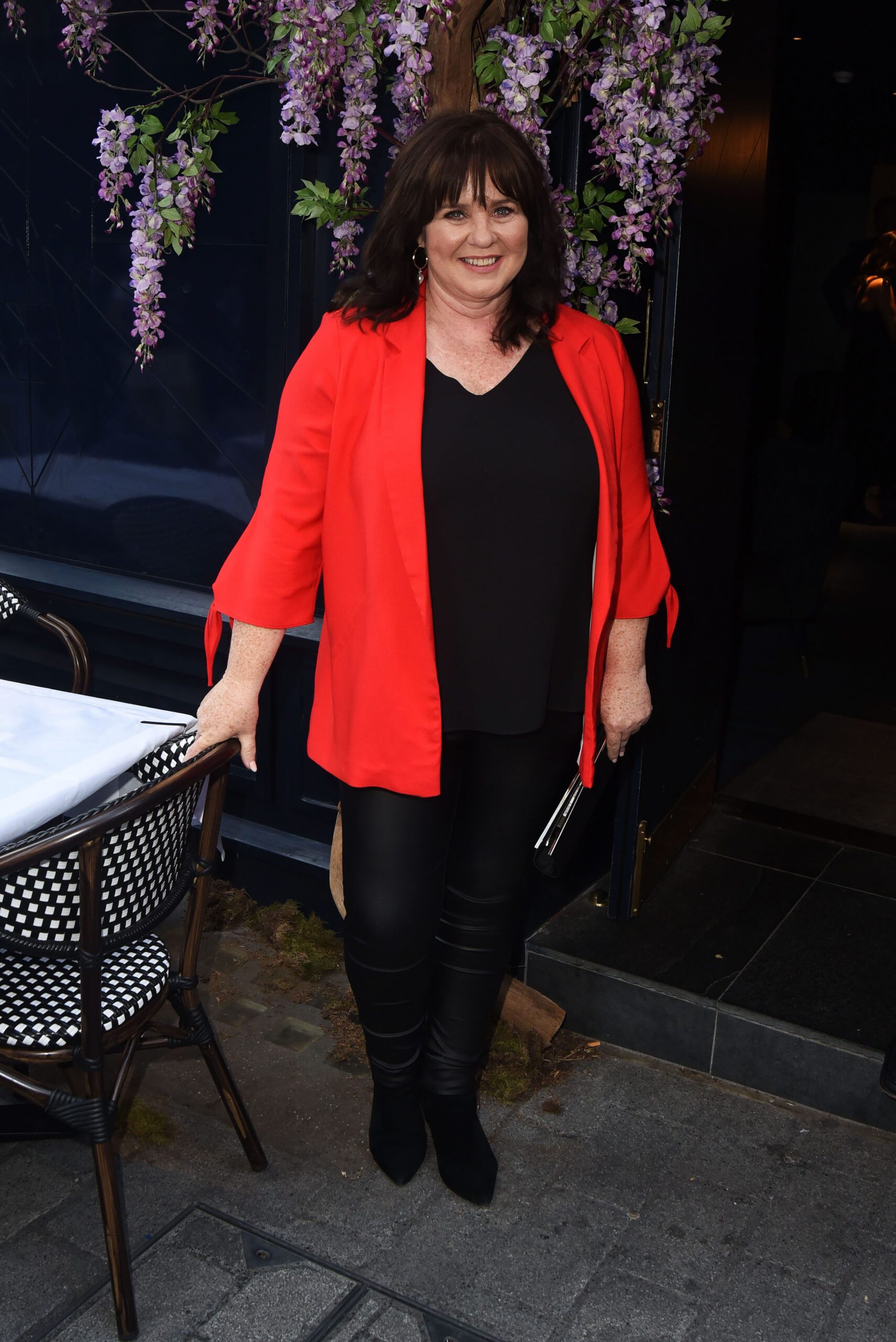 Coleen Nolan smiling in a red jacket