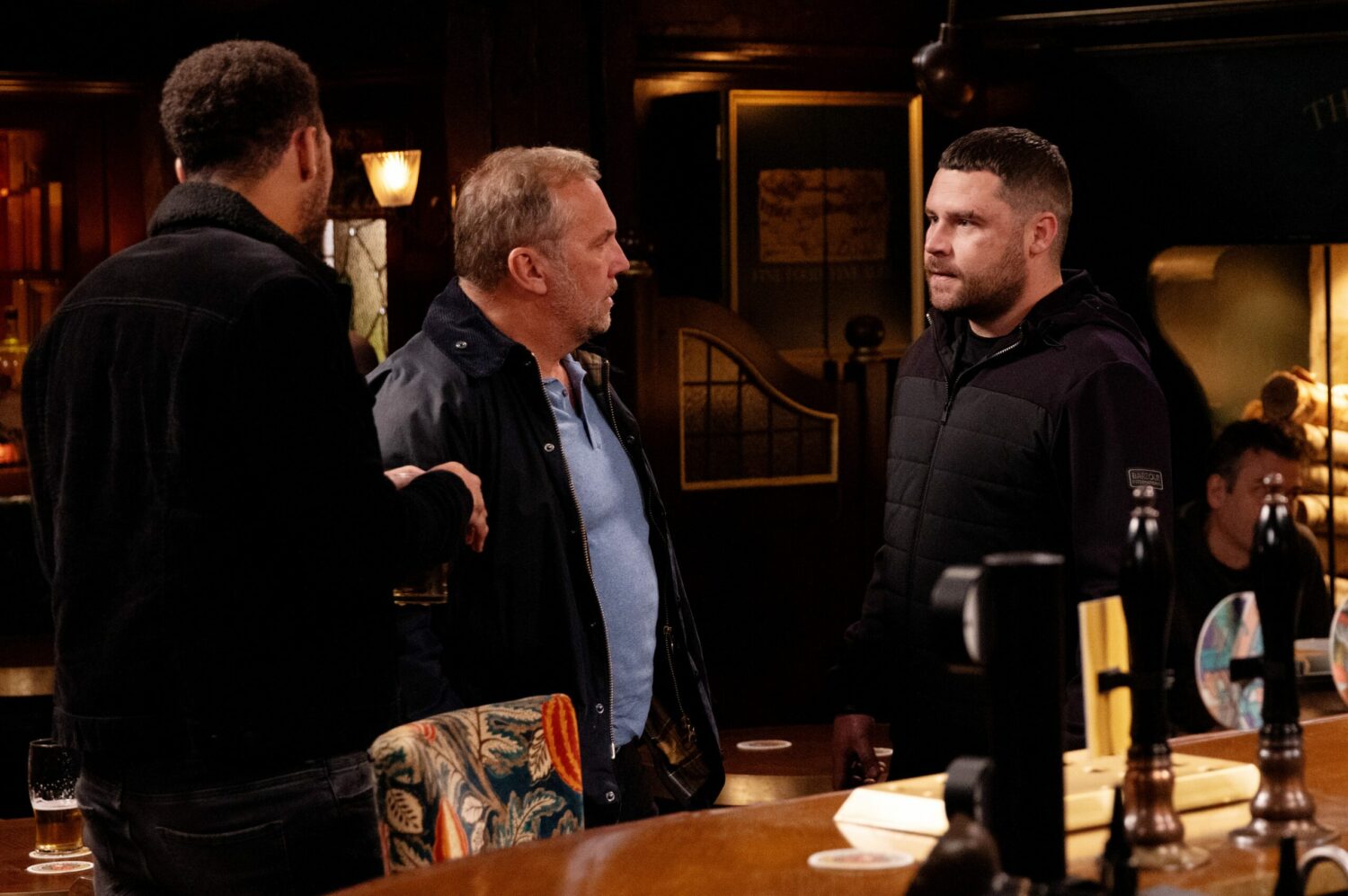 Emmerdale's Will is standing between Billy and Aaron in the pub