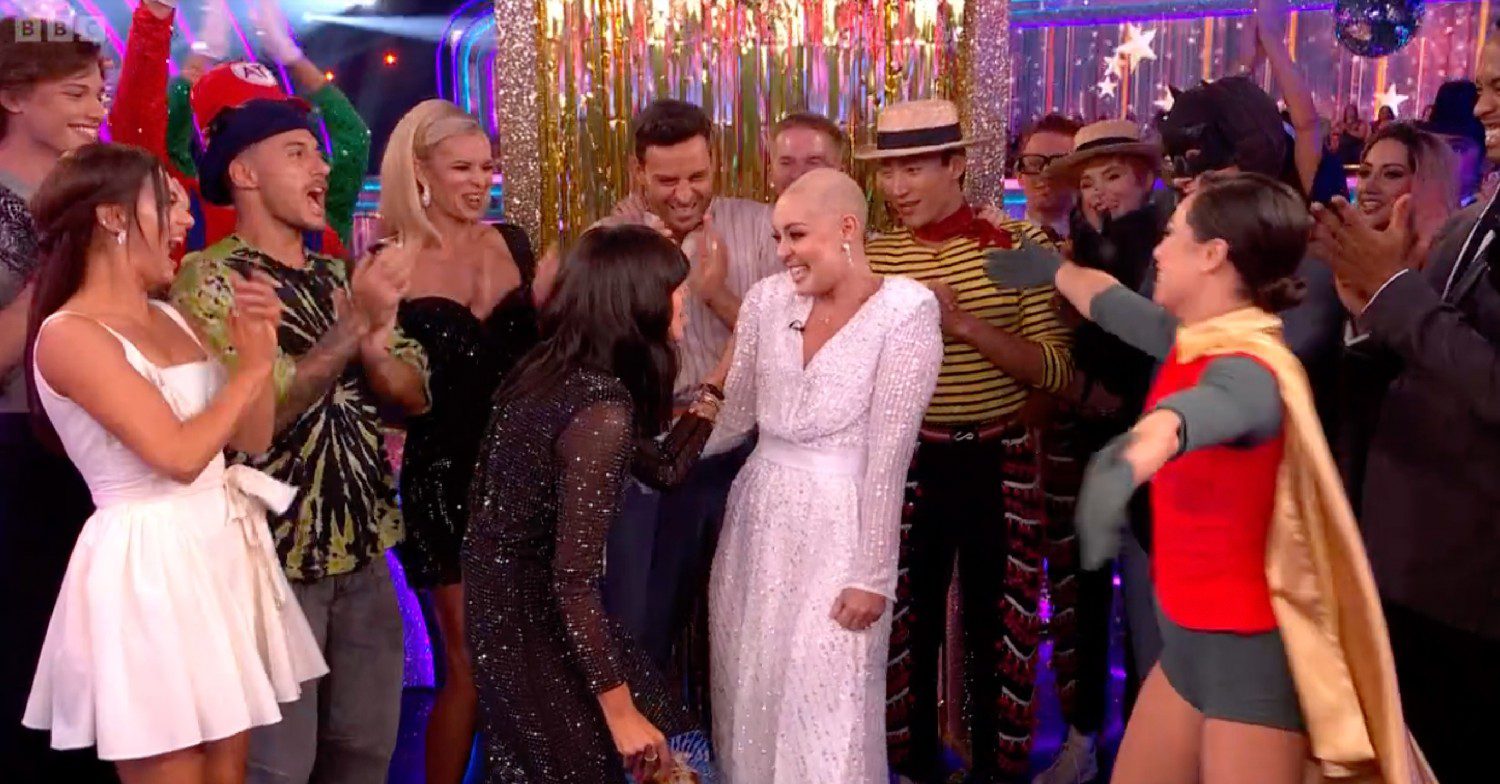 Amy Dowden smiling as she appeared on Strictly Come Dancing and is surrounded by her former colleagues 
