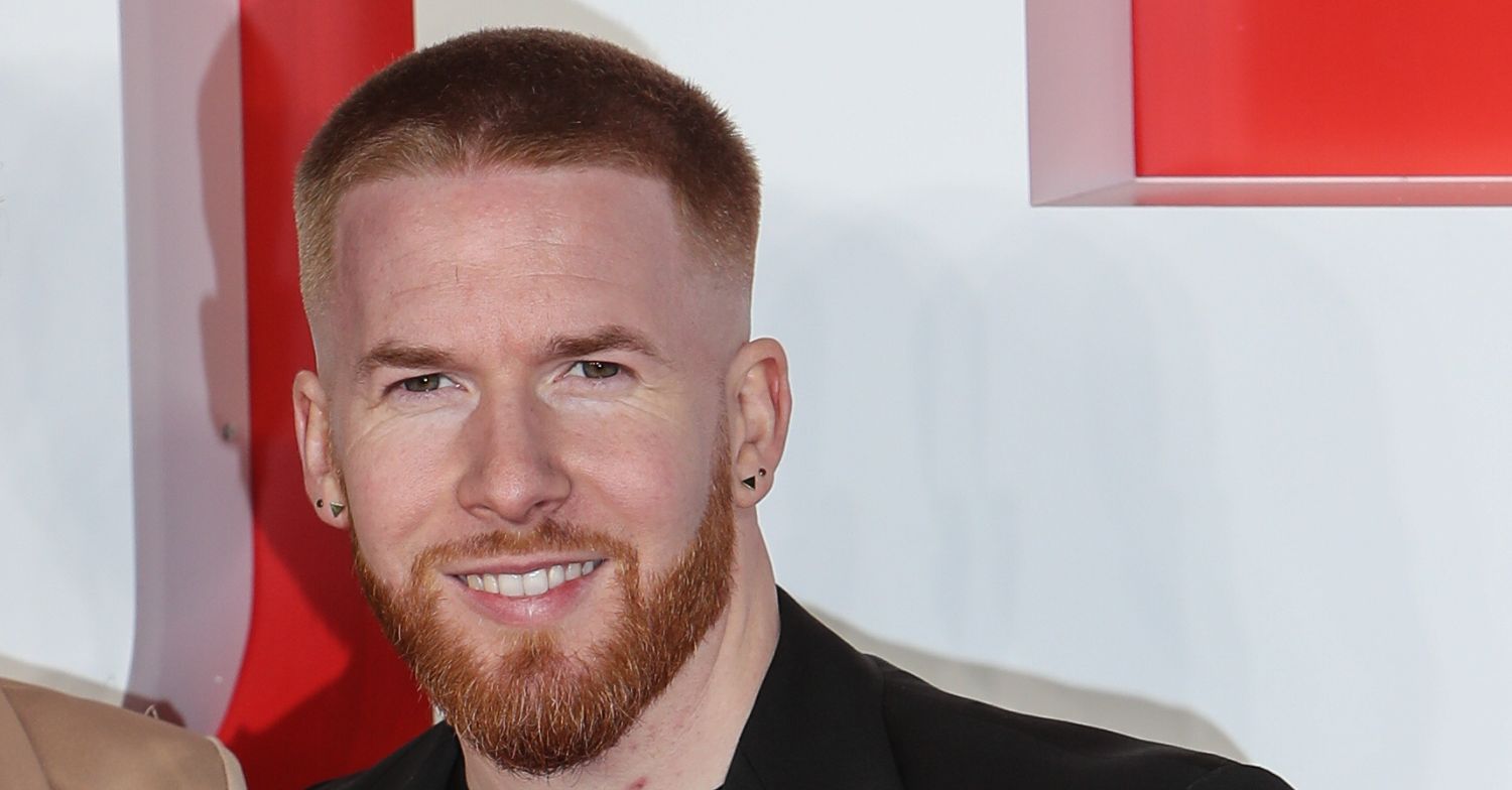 Neil Jones smiling on the red carpet