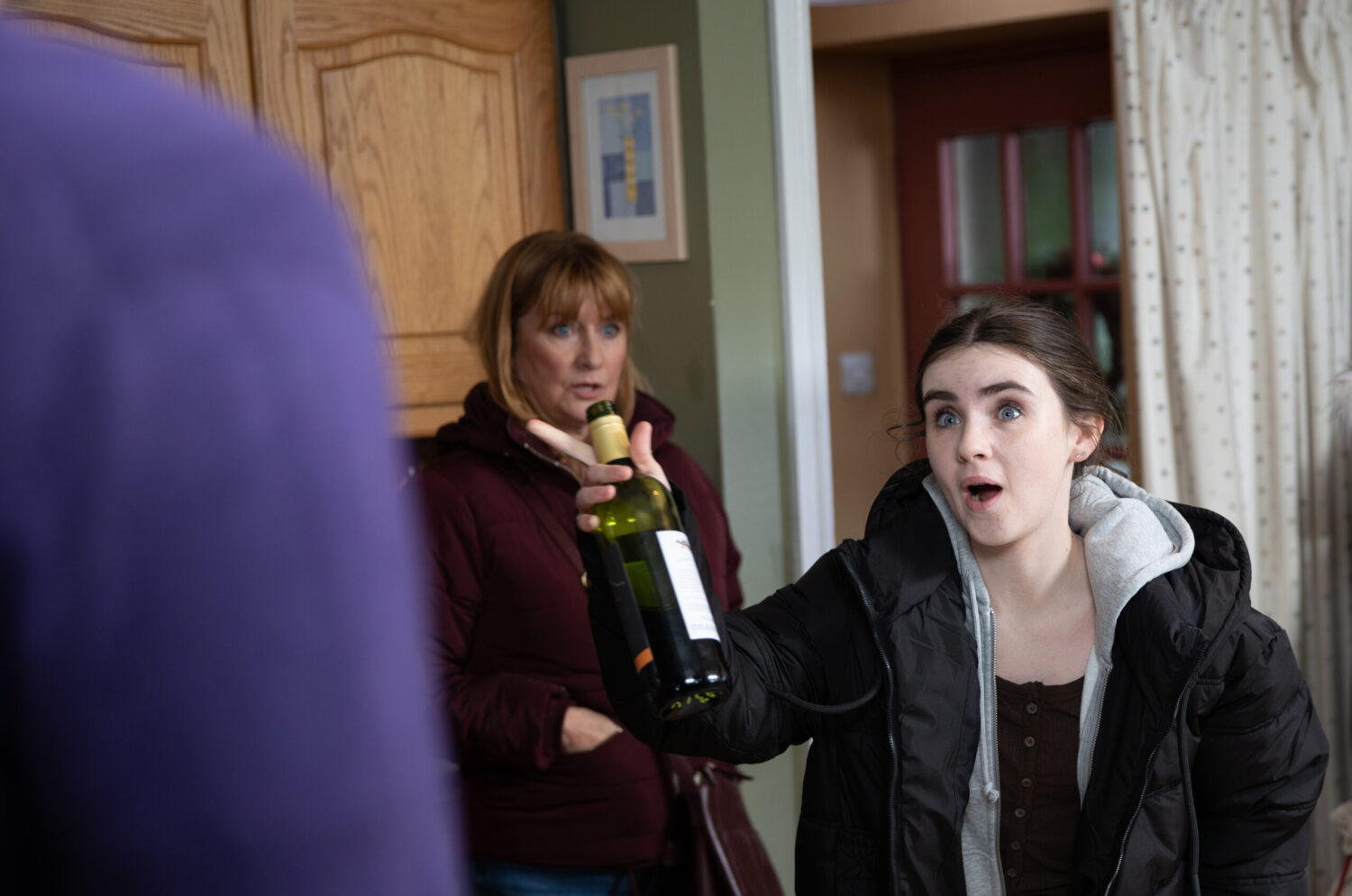 Emmerdale's April holding a bottle of alcohol