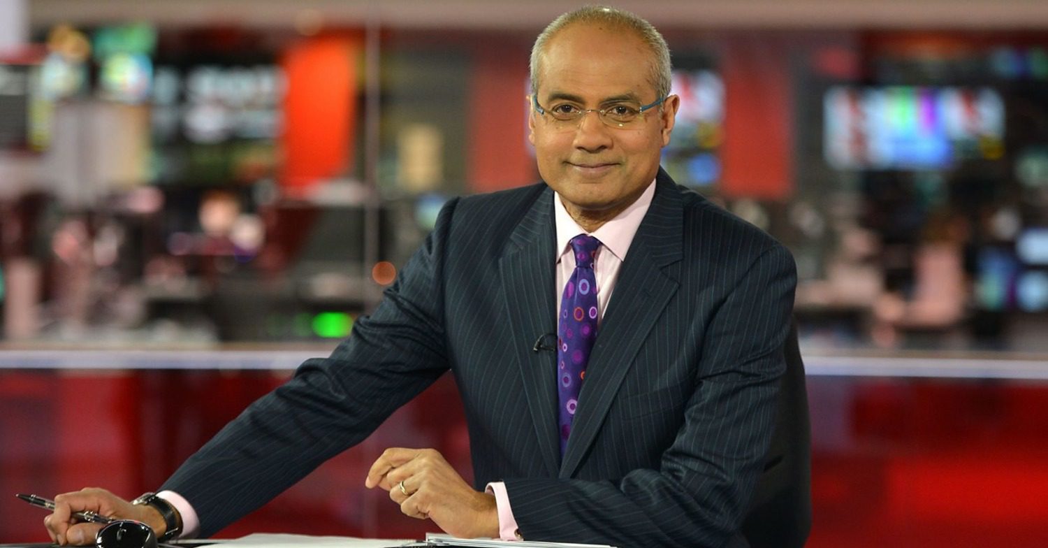 George Alagiah smiling while presenting the news