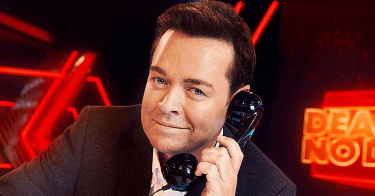Stephen Mulhern smiling holding a phone to his ear