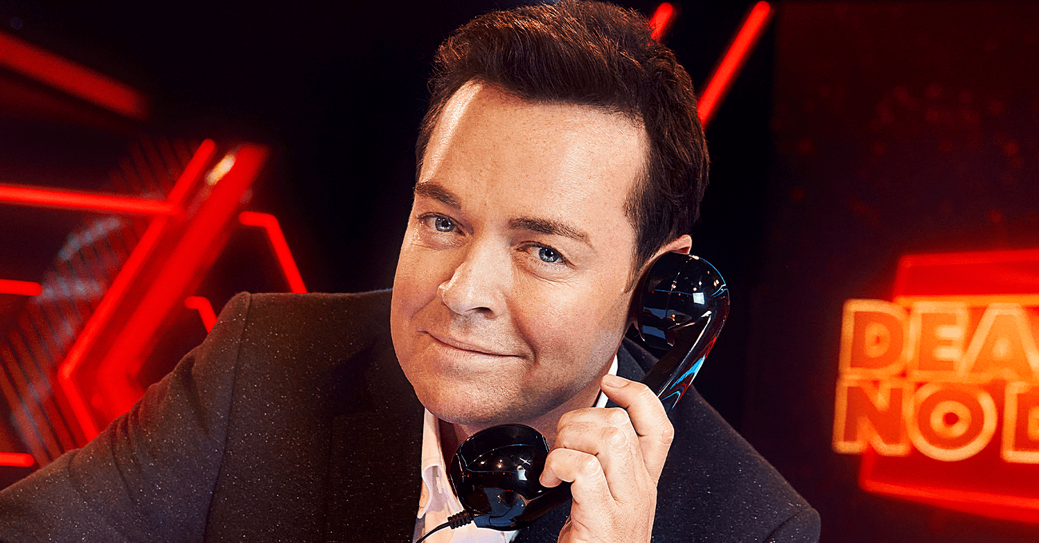 Stephen Mulhern smiling holding a phone to his ear