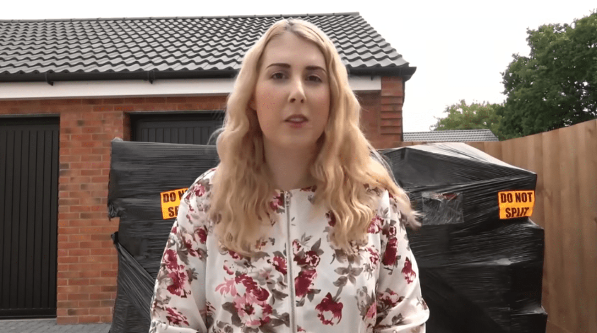 Coupon Queen Holly Jay-smith stands in front of her garage with two large pallets of goods