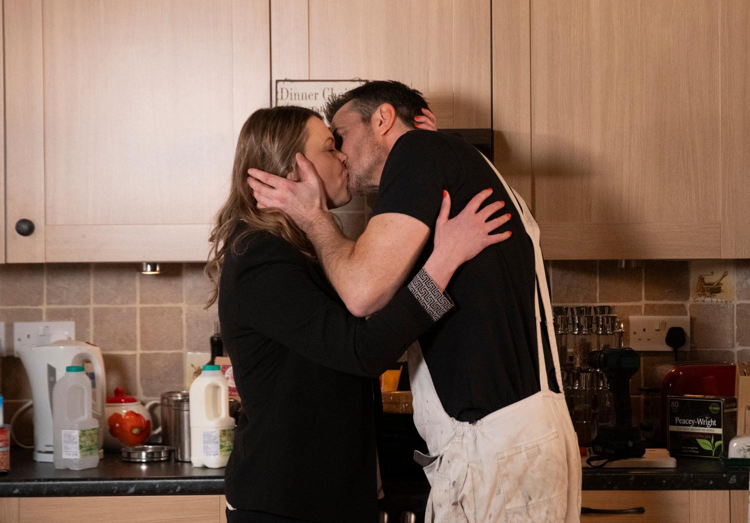 Coronation Street's Tracy and Tommy are kissing each other in the kitchen