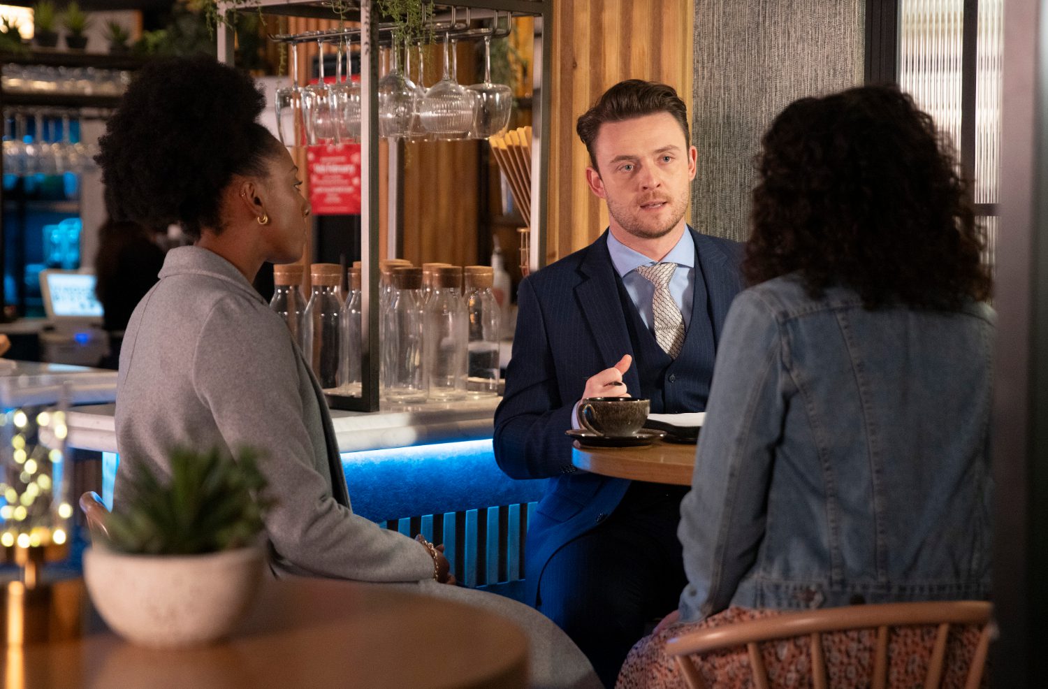 Joel looking awkward as he talks to two women on Corrie