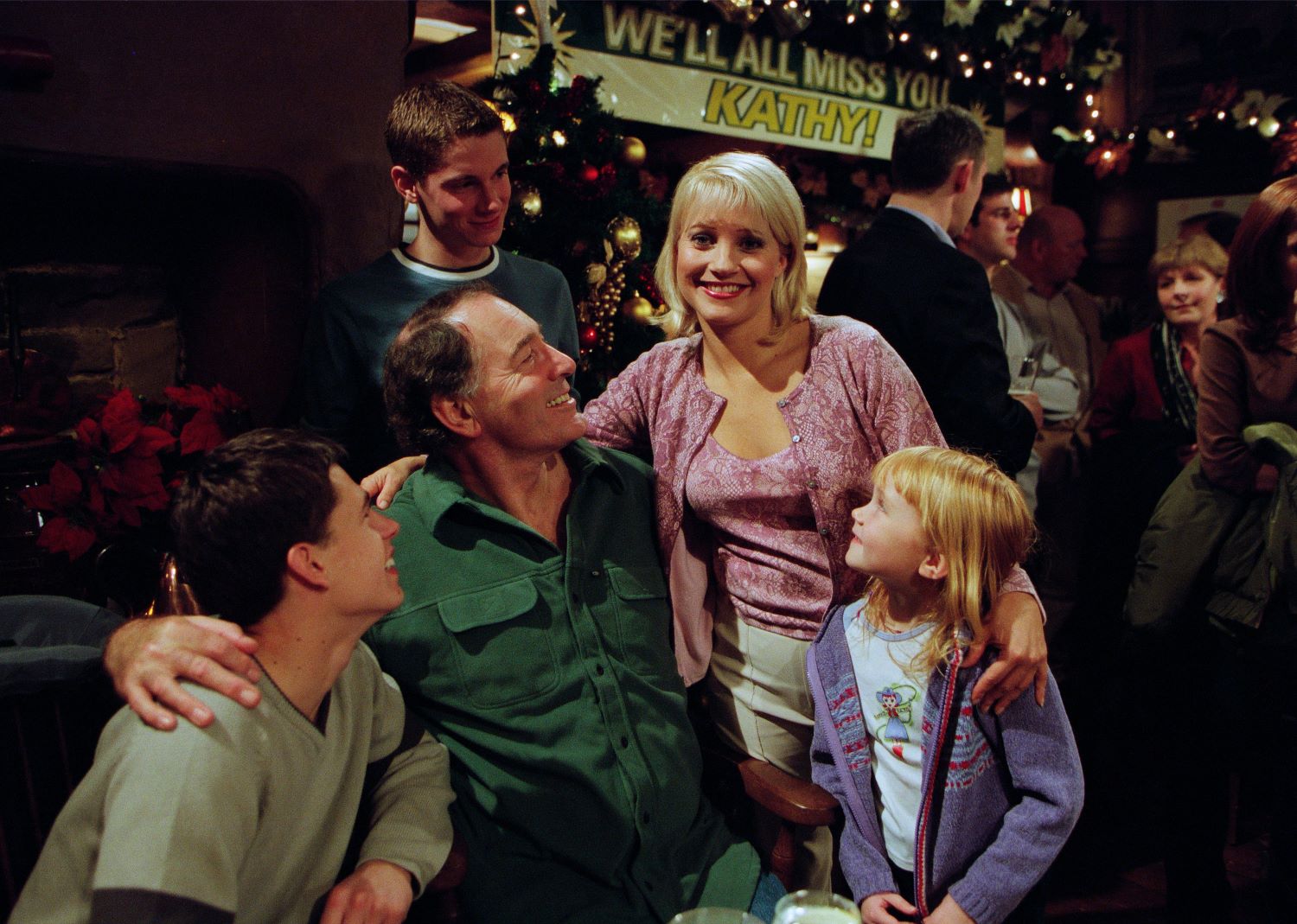 Kathy Glover in Emmerdale with Andy Sugden, Jack Sugden, Robert Sugden and Victoria Sugden smiling in the pub