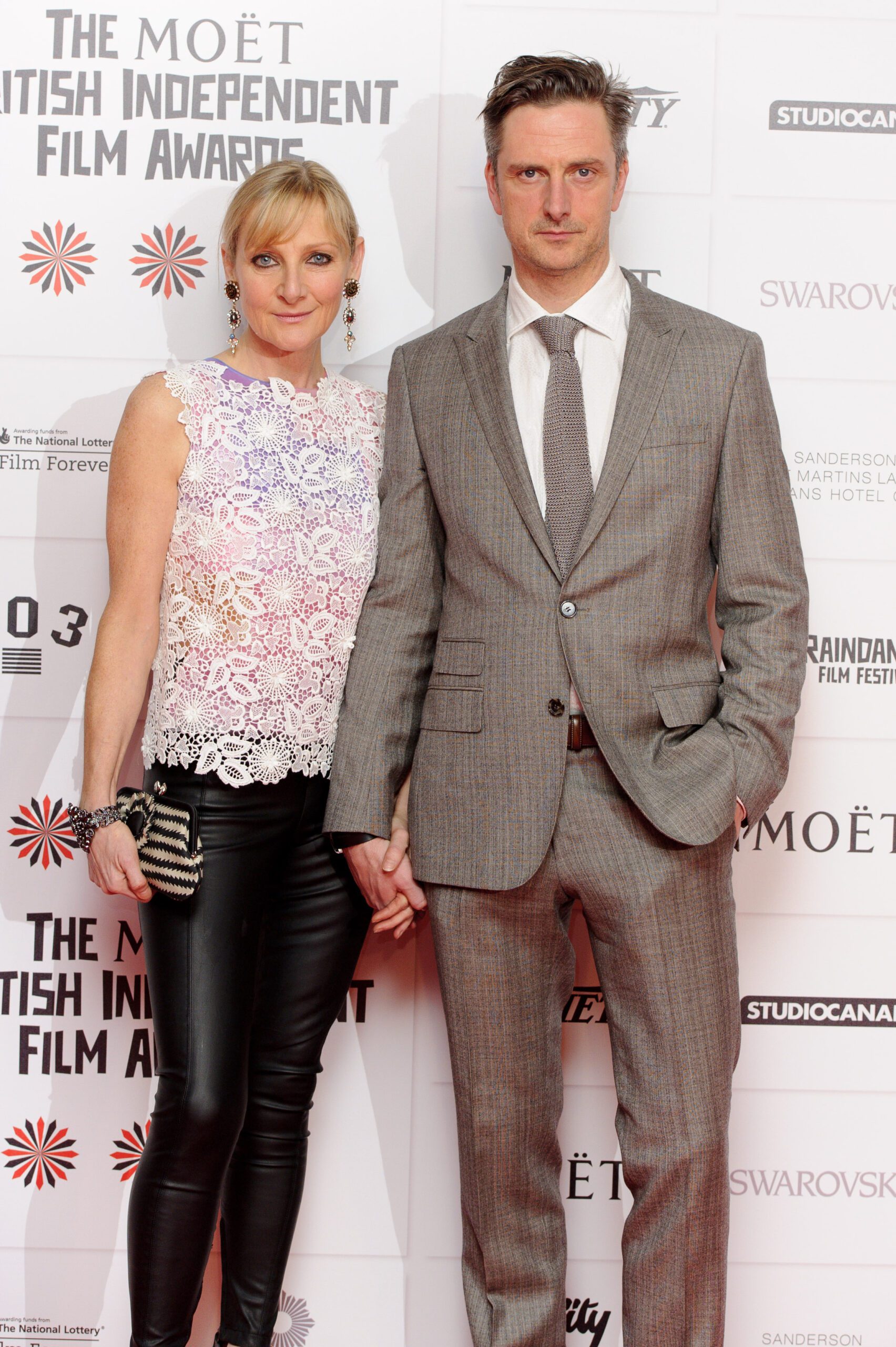 Lesley Sharp and husband Nicholas Gleaves hold hands at red carpet event