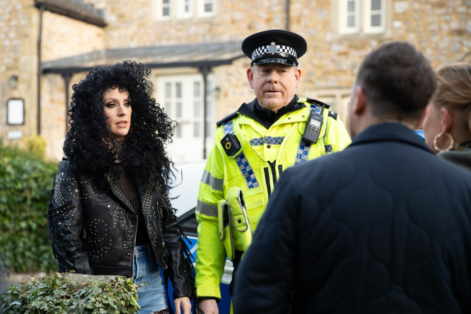 Kerry dressed as Cher is brought home by PC Swirling in Emmerdale