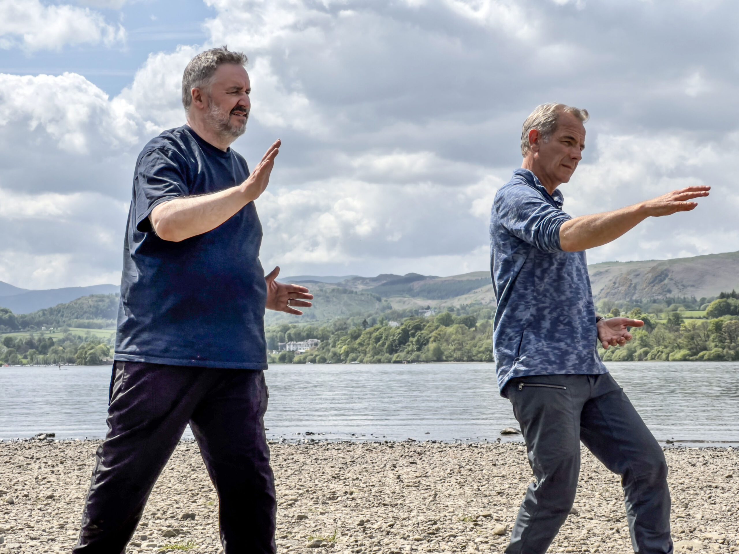 Mark Benton and Robson Green dancing together in the Lake District