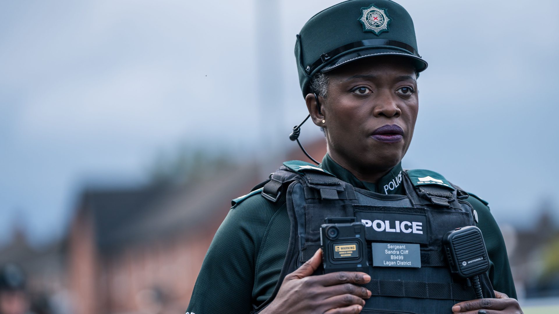 Candid shot of Andi Osho as Sandra Cliff wearing police uniform